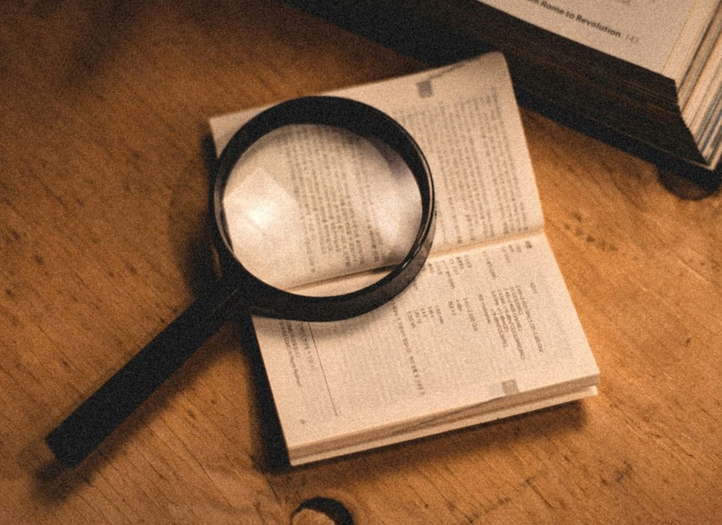 a magnifying glass sitting on top of an open book